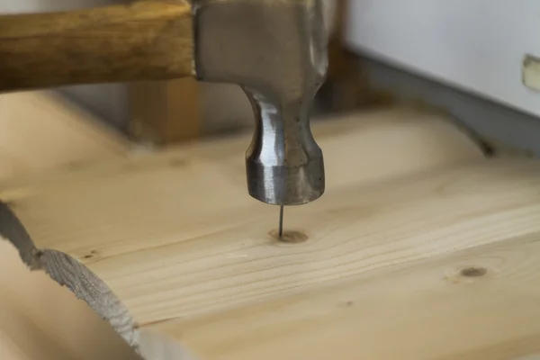 Hamer en spijker gebruiken op hout bokeh achtergrond — Stockfoto