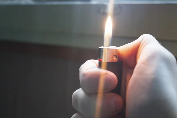 Encendedor ardiente en la mano del hombre — Foto de Stock