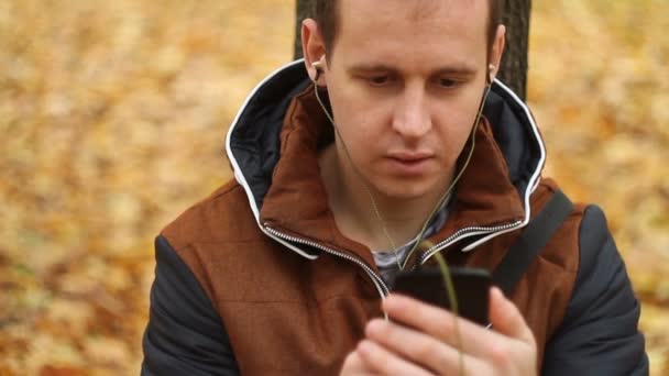 Fiatal férfi hallgató-hoz zene-ra smartphone — Stock videók