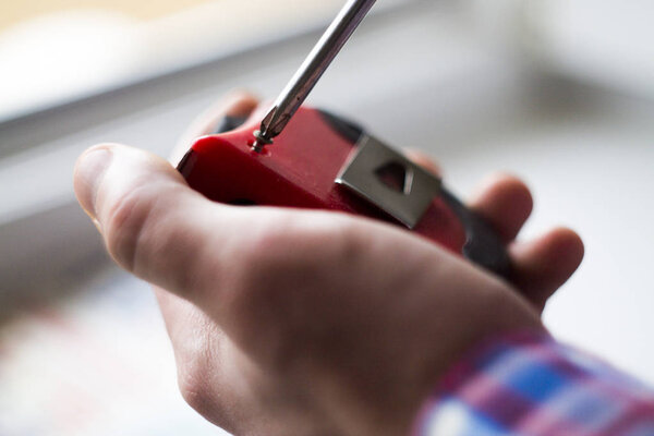 man unscrews the screw with a screwdriver
