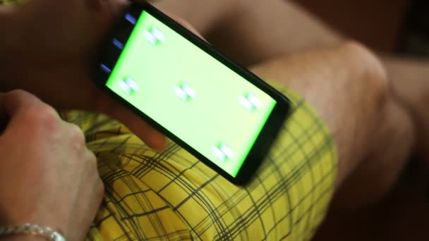 Hombre y un teléfono inteligente de pantalla verde — Vídeos de Stock