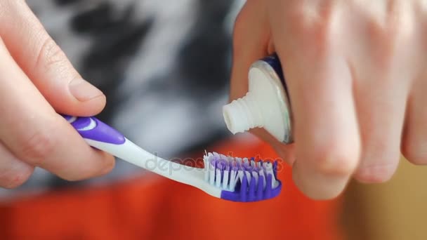 Чоловік стискає зубну пасту на щітці — стокове відео