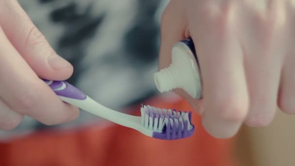 Мужчина сжимает зубную пасту на щетке — стоковое видео