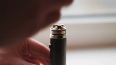 Adam elektronik sigara e-suyu ile doldurma. Depo tankından atomizer ve pil ayırma adam aromalı sıvı e-nikotin içermiyor olabilir veya olmayabilir suyu ile doldurmak için.