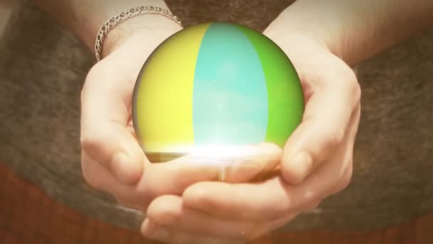 La boule colorée tourne dans les mains de l'homme — Video