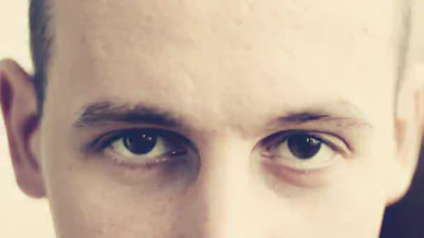 Ein junger Mann mit braunen Augen blickt in die Kamera — Stockvideo