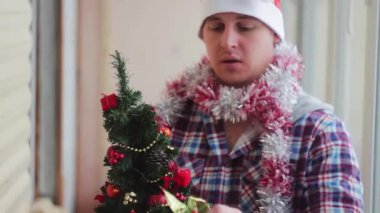 Adam güzel giyinir parıldayan küçük Noel ağacı