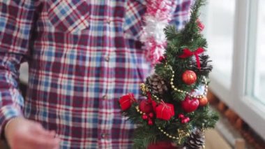 Adam güzel giyinir parıldayan küçük Noel ağacı