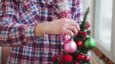 Adam güzel giyinir parıldayan küçük Noel ağacı