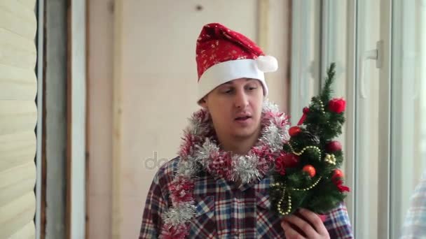 Adam güzel giyinir parıldayan küçük Noel ağacı — Stok video