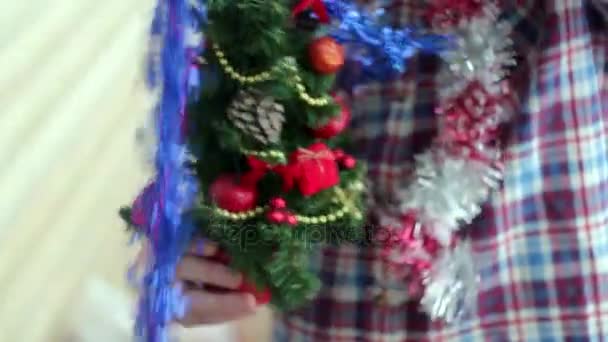 Άντρας ντύνεται όμορφα μικρό λαμπερό χριστουγεννιάτικο δέντρο — Αρχείο Βίντεο