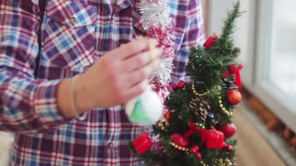 Mann kleidet schönen kleinen leuchtenden Weihnachtsbaum — Stockvideo