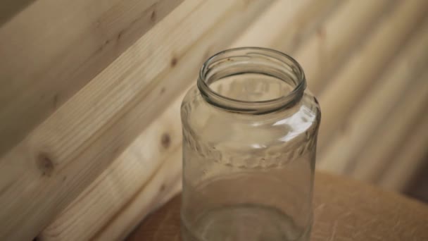 便士掉在木制背景的透明罐子里 — 图库视频影像