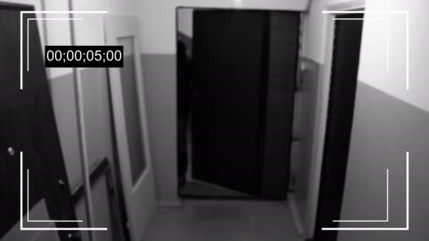 Un hombre armado en la máscara rompe la puerta y rompe la cámara de seguridad y manejar un arma — Vídeos de Stock