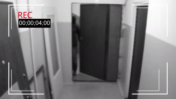 Hombre en la máscara rompe la puerta y trata de romper la cámara de seguridad — Vídeos de Stock