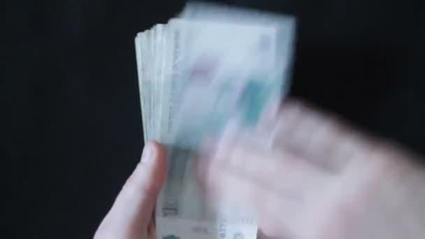 Un hombre sosteniendo en una mano los billetes, y la otra mano lanza alrededor — Vídeo de stock