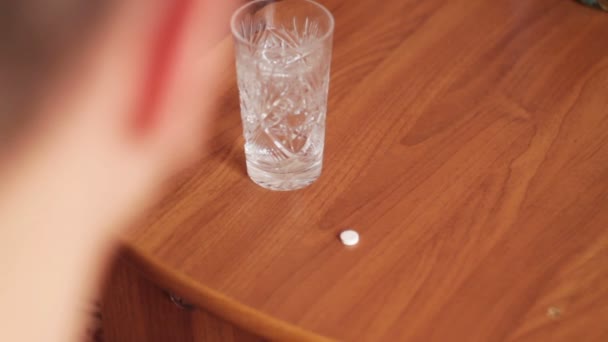 Человек смывает таблетку стаканом воды — стоковое видео