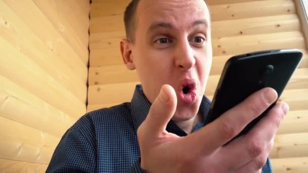 Розчарований чоловік кричить на своєму смартфоні — стокове відео