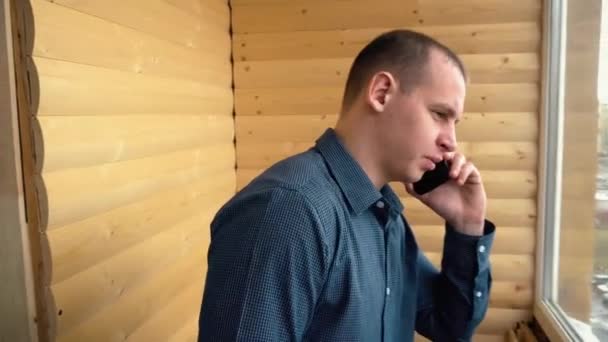 Разочарованный мужчина кричит на свой смартфон — стоковое видео