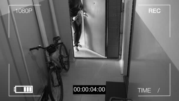 Камера спостереження спіймала злодія, зламала двері і вкрала велосипед — стокове відео
