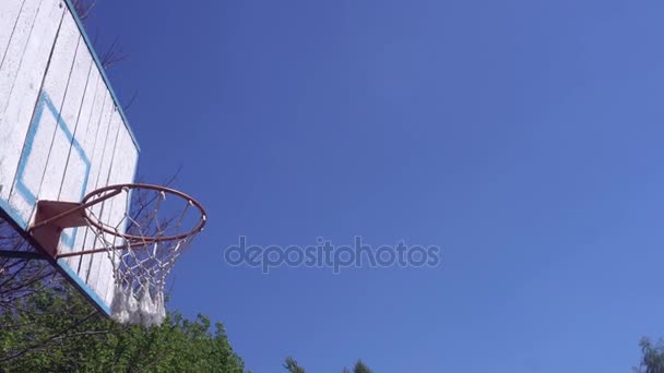 Застаріле баскетбольне кільце на фоні блакитного неба — стокове відео