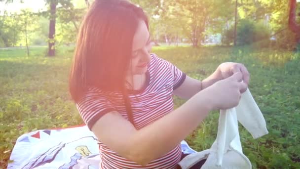 Šťastná Mladá těhotná žena s baby svetr — Stock video