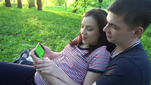 Jeune couple heureux avec smartphone, en plein air — Video
