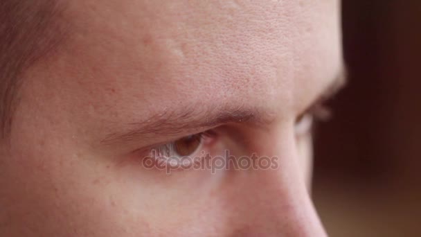 Ένας νεαρός άνδρας με καστανά μάτια, κοιτάζοντας προς την πλευρά, μια επίδραση του υπολογιστή — Αρχείο Βίντεο