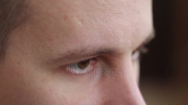 Een jonge man met bruine ogen op zoek naar de kant, een computer-effect — Stockvideo