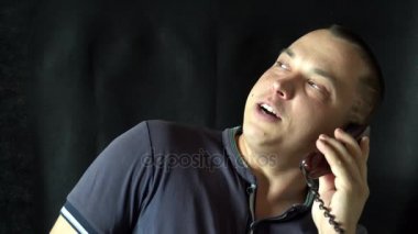 genç adam evi telefonda konuşurken. siyah arka plan