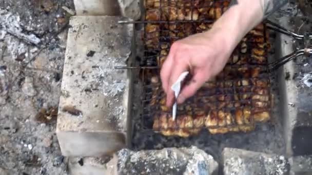 塑料叉子刺穿烧烤油炸美味块肉。手用塑料叉子检查肉类的烤架上的准备。烹饪在烤架上烤的肉质鲜美。特写 — 图库视频影像
