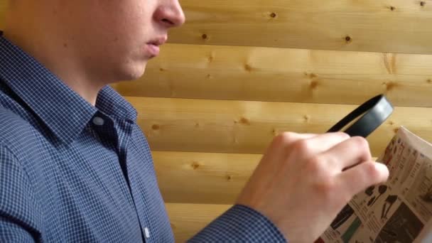 Jonge zakenman leest een krant met een vergrootglas — Stockvideo