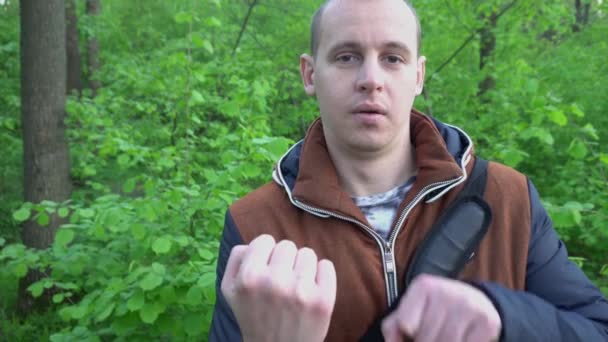 El joven en la naturaleza, mostrando el dedo medio a la cámara — Vídeos de Stock