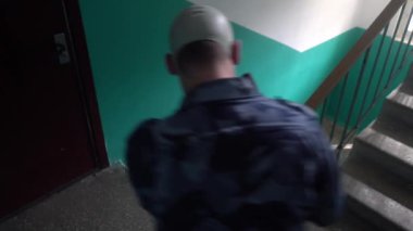 Askeri üniforma giymiş, gaz maskesi takmış bir muhafız binaya girmişti.