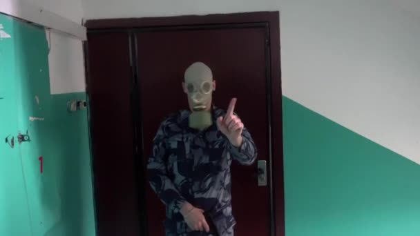 De bewaker, gekleed in militair uniform in het masker komt niet langs de man met de camera — Stockvideo