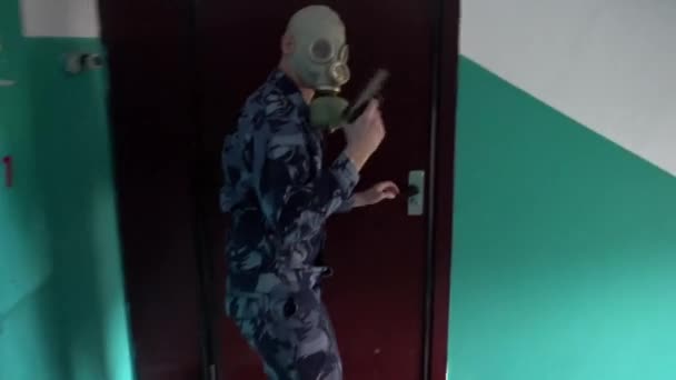 Wachmann in Militäruniform mit Gasmaske stürmt das Gebäude — Stockvideo