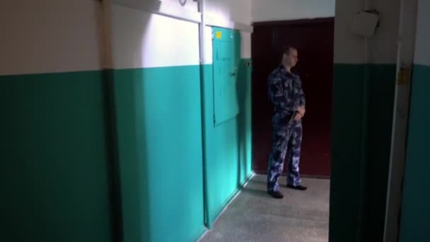 Bewaker gekleed in militaire uniform bewaakt het appartement — Stockvideo