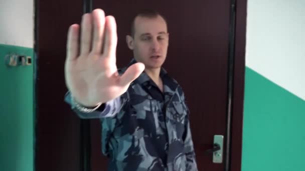 Охранник одет в военную форму не позволяйте новостной камере и закрывает камеру рукой — стоковое видео