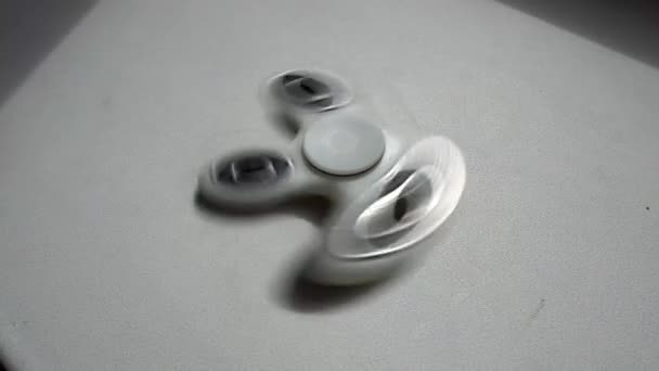 Um girador de mão de fiação de alta velocidade ou fidget spinner sobre o fundo branco branco — Vídeo de Stock