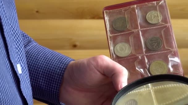 Numismaticus acht oude munten door vergrootglas — Stockvideo