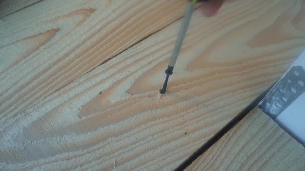 Male hand twist the screw into a wooden Board using a power screwdriver — Stock Video