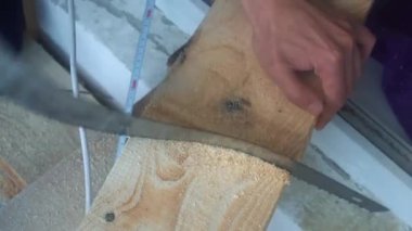 Tahtayı testereyle kesen bir el testeresiyle çalışmak
