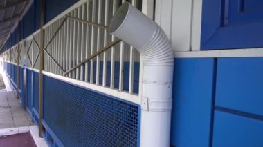 Mavi duvarın arka planında beyaz iniş borusu
