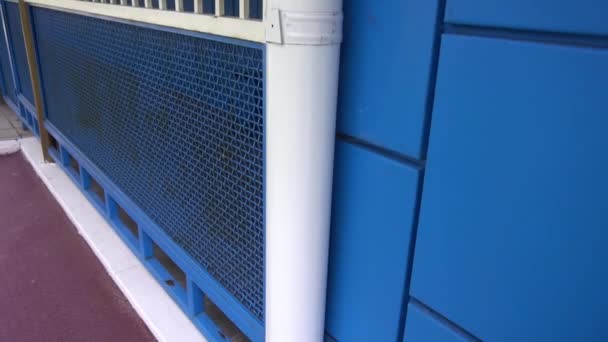 White downpipe on the background of blue wall — Stock Video