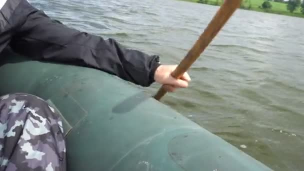 Pescador flutua em um barco a remo com uma pá — Vídeo de Stock