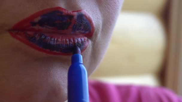 Mädchen bemalt rote Lippen mit blauem Filzstift — Stockvideo