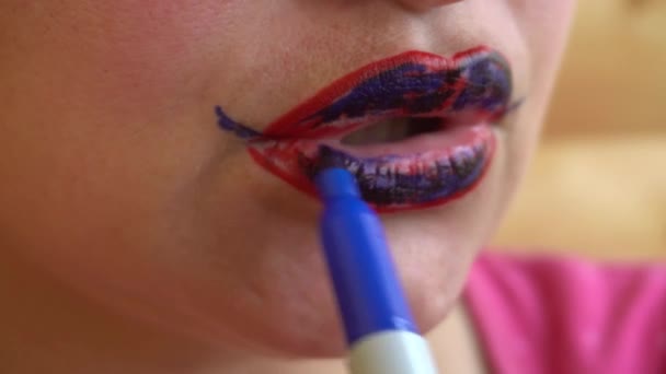 Flicka målar den röda läppar blå tuschpenna — Stockvideo