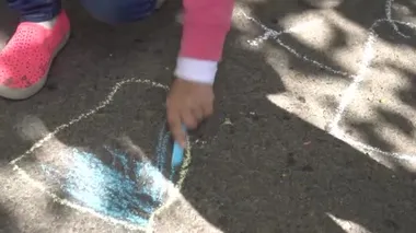 Bebek el ile renkli tebeşirler kaldırımda çizimi