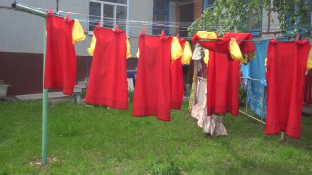Vestidos vermelhos secando na rua — Vídeo de Stock