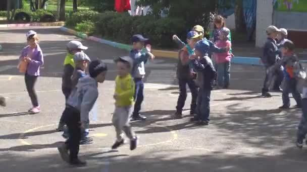 Курск, Россия - 1 июня 2017 года: дети играют и танцуют на детской площадке в детском саду. День защиты детей — стоковое видео